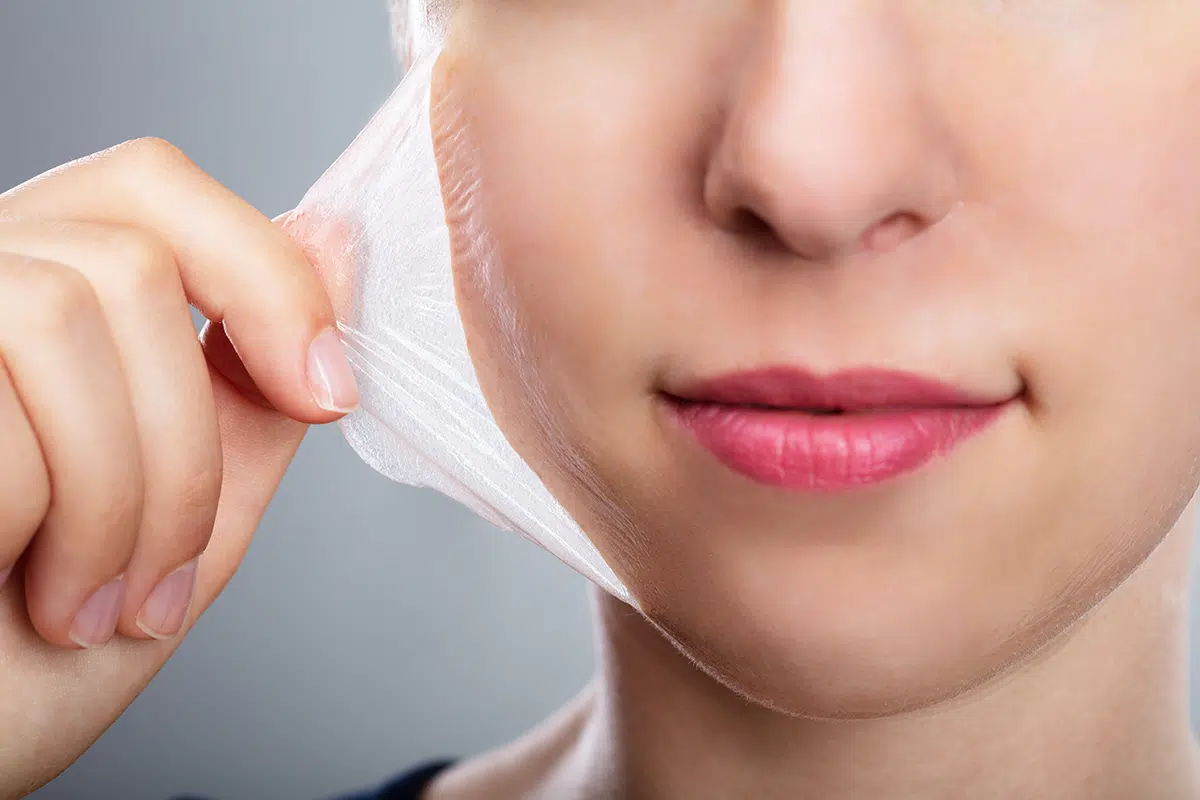 woman removing peeling mask from her face